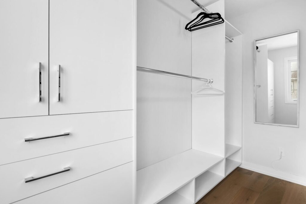 Organized walk-in closet with white cabinets